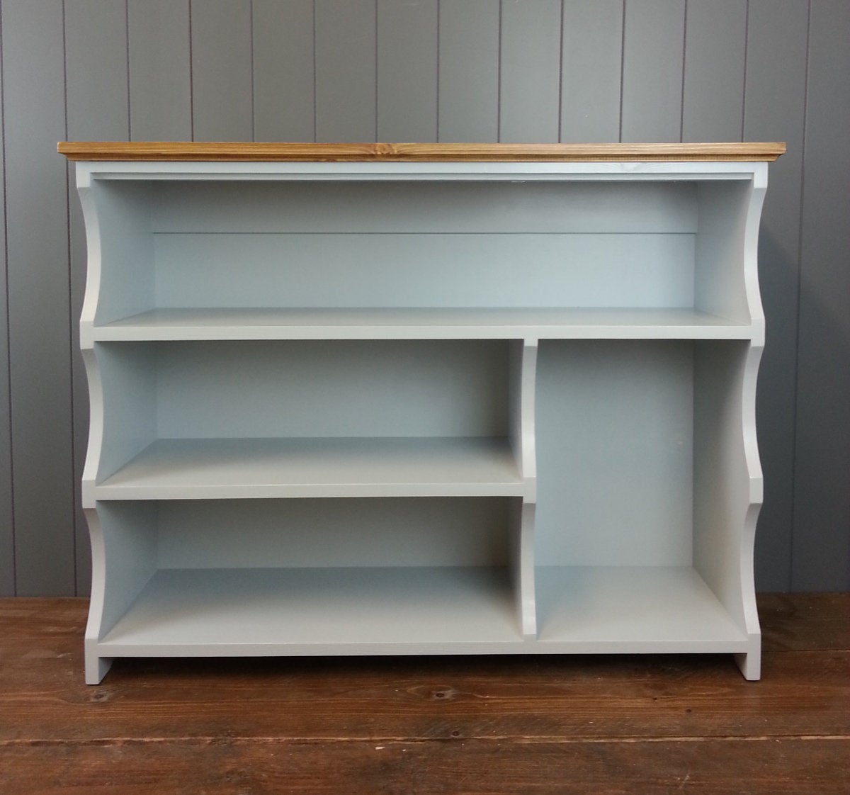 Painted shoe rack with three shelves for shoes and a compartment for boots.