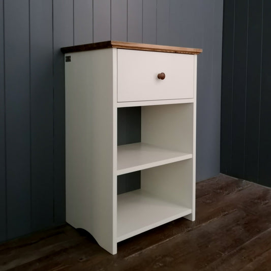 A bedside table, side table or lamp table with a shelf and deep drawer, painted white with an antique pine top.